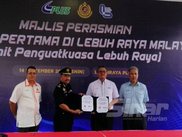 Shaharuddin (kiri) bersama Mohd Shuhaimi (kanan) menyaksikan serahan MoU antara JPJ dengan PLUS.