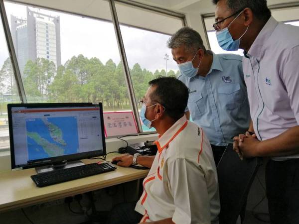 Shaharuddin diiringi Mohd Shuhaimi dan Ketua Pegawai Operasi PLUS, Zakaria Ahmad Zabidi (kanan) melihat paparan skrin yang terdapat di bilik kawalan Pusat Kawalan Penguatkuasa Lebuhraya.