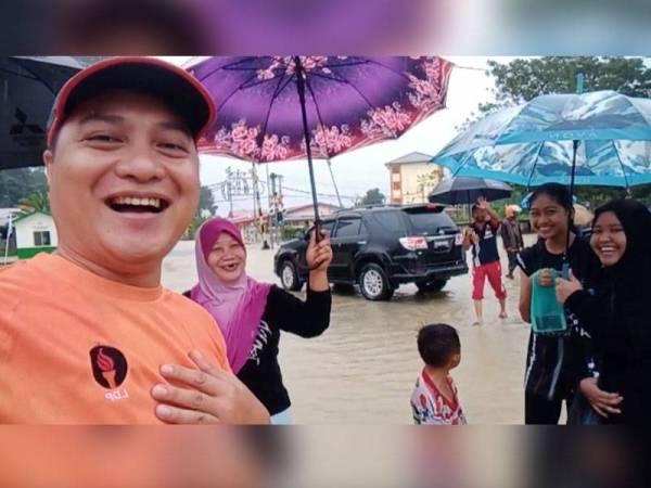 Janrywine (kiri) bermesra bersama penduduk setempat ketika meninjau kawasan terjejas banjir sekitar pekan Kinarut pagi tadi.