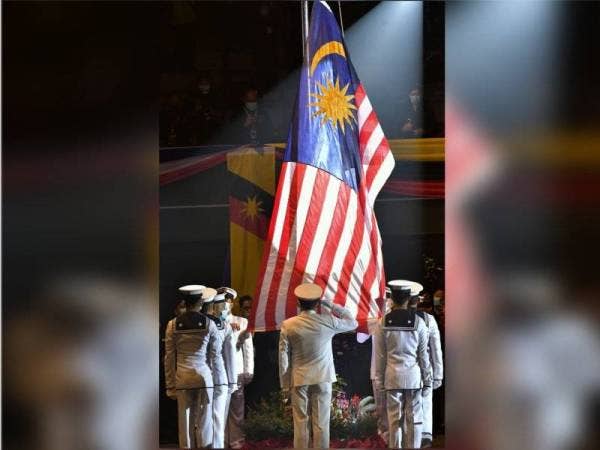 Para pegawai dan anggota Tentera Laut Diraja Malaysia (TLDM) menaikkan Jalur Gemilang pada Majlis Sambutan Hari Malaysia di Stadium Tertutup Sibu hari ini.  - Foto Bernama