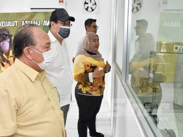 Henry (kiri) melihat sendiri kaedah pemprosesan madu kelulut asli.