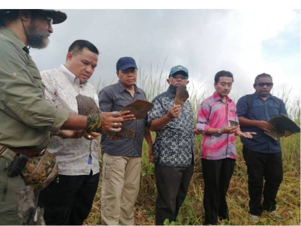 Mesran (tiga,kanan), Mohd Nasruddin (sebelah) dan Akramuddin (dua kiri) menunjukkan serpihan tembikar yang turut ditemui di kawasan tersebut.