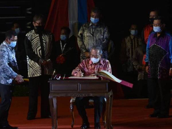 Muhyiddin yang diiringi Saifuddin (belakang, dua dari kanan), Dr Abang Abdul Rahman (belakang, dua dari kiri) dan Aidi (kiri) menandatangani Buku Khas Hari Malaysia sempena Sambutan Hari Malaysia 2020 ke-57 Peringkat Kebangsaan di Stadium Tertutup Sibu malam tadi. -Foto: Ihsan JaPen