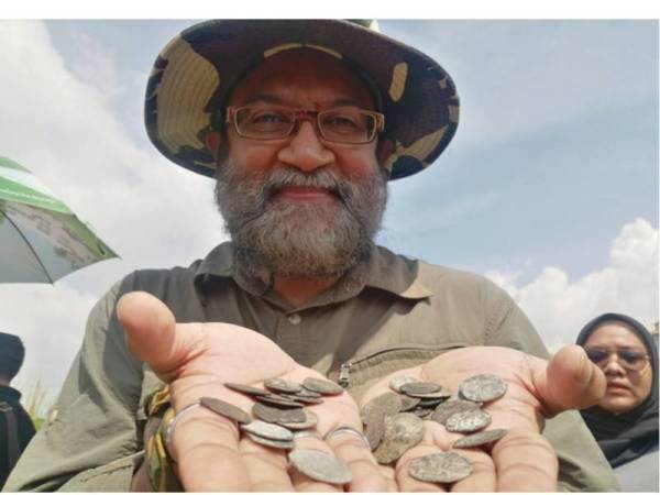 Dionysius menunjukkan duit syiling Portugis dan Belanda yang ditemui di kawasan semak Paya Bakau di Melaka Raya, di sini, hari ini.