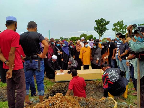 Shabri (duduk, kiri) dan Zalina tidak dapat menahan kesedihan ketika menatap wajah anak mereka buat kali terakhir sebelum dikebumikan di Tanah Perkuburan Islam Raudhatul Solihin, Sungai Petani petang tadi.