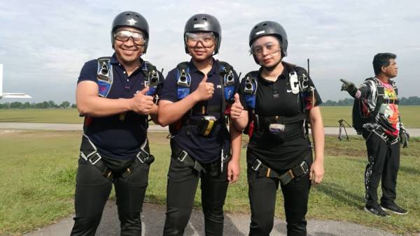 Dr Sani (kiri) bersama Izzat Izzedin dan Wan Razlila bersemangat sebelum membuat terjunan udara di Lapangan Terbang Tekkah di sini hari ini.