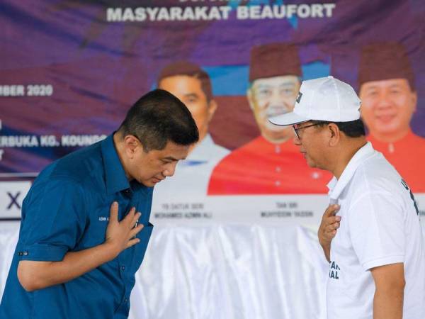 Mohamed Azmin (kiri) meletakkan tangan di dada tanda ucap salam dalam normal baharu kepada Isnin ketika hadir pada Majlis Ramah Mesra bersama Masyarakat Beaufort di Dewan Kampung Koundo, Kebatu. - Foto Bernama