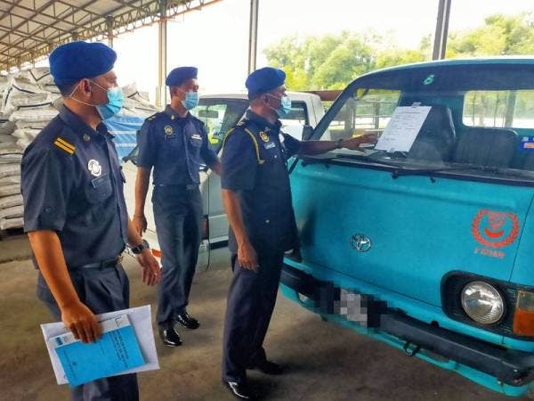 Muniandy ( kanan) menunjukkan lori satu tan yang disita pihaknya ketika serbuan di Kampung Changhai semalam.
