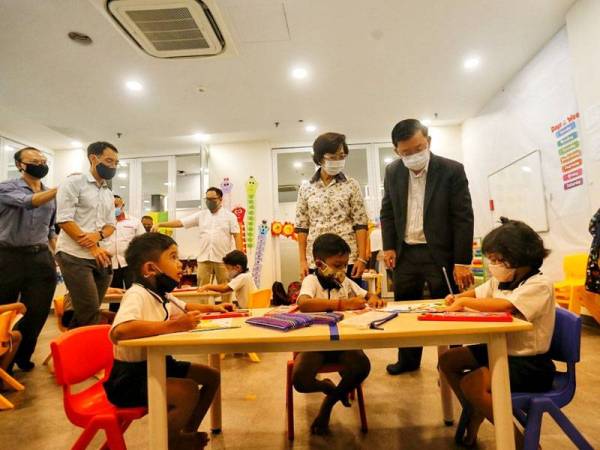 Kon Yeow (kanan) meninjau Tadika Whytehouse di Komtar selepas merasmikan pembukaannya tadi.