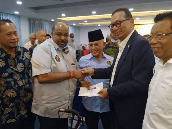 Abdullah (kanan) dan Samsolbari (dua dari kanan) menyerahkan sumbangan kepada ahli Mubarak S Ramis (dua dari kiri) pada Majlis Mesyuarat Agong Tahunan Mubarak Johor kali ke - 19, hari ini.