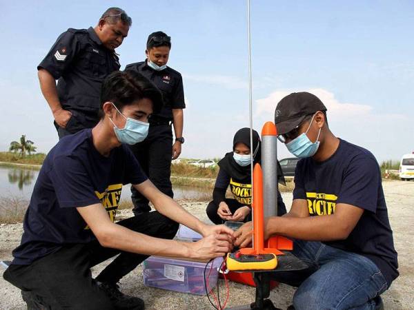 Pelajar Universiti Putra Malaysia Hazimi Ismail 22, (kiri) dan Nurul Hafizah Azhar, 22, (dua, kanan) serta pelajar Universiti Teknologi Mara Shah Alam, Khalkhalas Kamaludin 22, (kanan) membuat persiapan untuk melakukan ujian pelancaran roket berskala kecil anjuran Marine Technology Company (MTC) Engineering Sdn Bhd dengan kerjasama empat buah universiti awam di Pusat Benih Padi Felcra Seberang Perak hari ini.