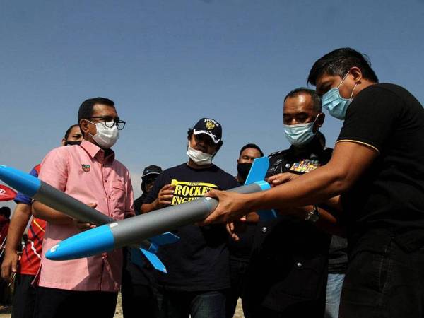 Penasihat Menteri Besar Perak, Datuk Zainol Fadzi Paharuddin (kiri) melihat roket ketika melakukan ujian pelancaran roket berskala kecil anjuran Marine Technology Company (MTC) Engineering Sdn Bhd dengan kerjasama empat buah universiti awam di Pusat Benih Padi Felcra Seberang Perak hari ini.