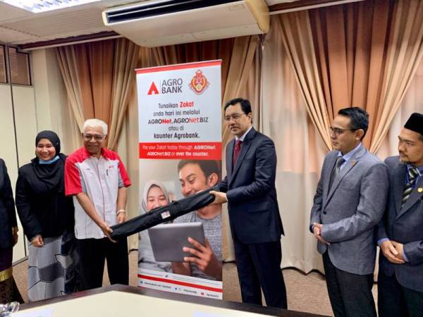 Zulkifle (tiga dari kanan) menerima gegantung dari Agrobank sebagai gimik perasmian Agrobank menjadi wakil kutipan zakat Maik di pejabat Maik semalam.