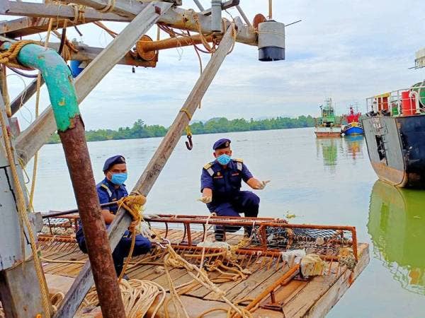 Muhd Nur Syam Asmawie (kanan) menunjukkan tangguk besi yang digunakan nelayan asing Vietnam untuk menangkap gamat.