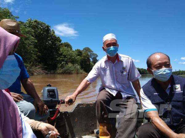Ruslan (baju putih) menyusuri Sungai Padas untuk bertemu penduduk Kampung Labi, Beaufort. 