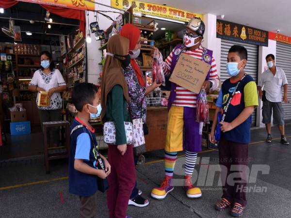 Yusmaniza mengenakan pakaian badut menjual air serbat kepada orang ramai di Pasar Chowrasta, Pulau Pinang bagi meneruskan kelangsungan hidup selepas pendapatannya sebagai badut terjejas akibat pandemik Covid-19.
