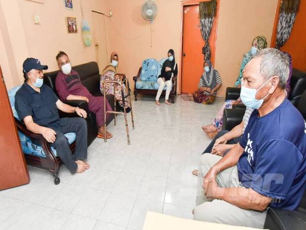 Mohd Arifin (kiri) ketika mengadakan ziarah ke rumah penduduk di Kampung Binsulok, Membakut semalam.