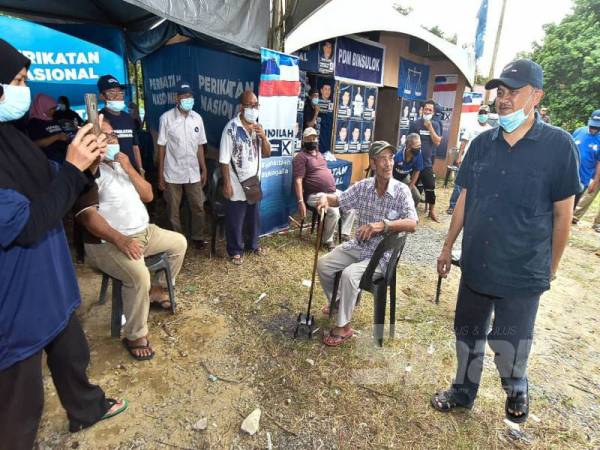 Mohd Arifin (kanan) ketika melawat Pusat Daerah Mengundi Binsulok, Membakut semalam.
