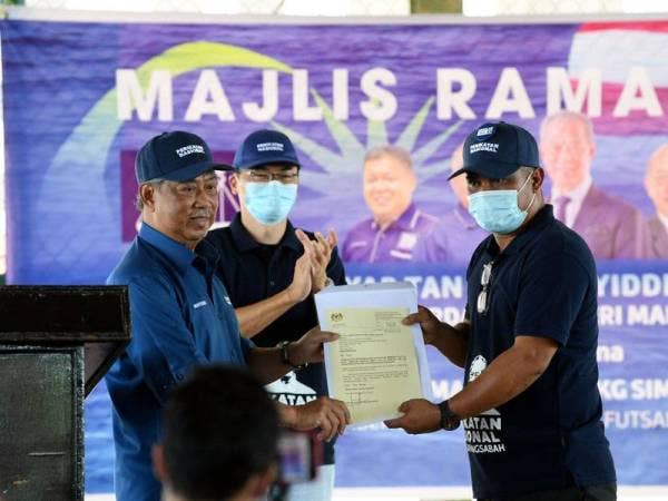 Perdana Menteri Tan Sri Muhyiddin Yassin (kiri) menyerahkan surat mengembalikan peruntukan untuk membaik pulih 24 buah jambatan di Kampung Sim Sim bernilai RM4.2 juta kepada Pengerusi Persatuan Nelayan Kawasan Sandakan, Shaiful Bahari Muin (kanan) ketika menghadiri majlis ramah mesra perdana bersama masyarakat Kampung Sim Sim hari ini. --fotoBERNAMA