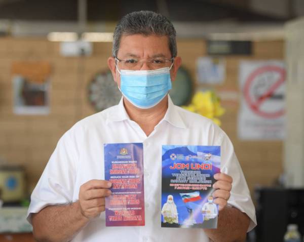 Saifuddin menunjukkan risalah ‘Jom Undi' dan ‘Kurangkan Risiko Dijangkiti Koronavirus' pada Program Info On Wheels (IOW) anjuran Jabatan Penerangan Malaysia (JaPen). -Foto Bernama