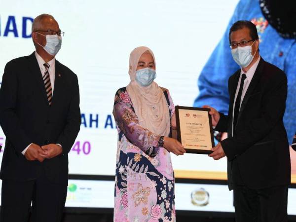 Noraini (tengah) menyerahkan cenderahati kepada Rektor UiTM Cawangan Johor, Profesor Dr Ismail Ahmad pada majlis pelancaran UiTM Prihatin di UiTM Shah Alam hari ini. - Foto Bernama