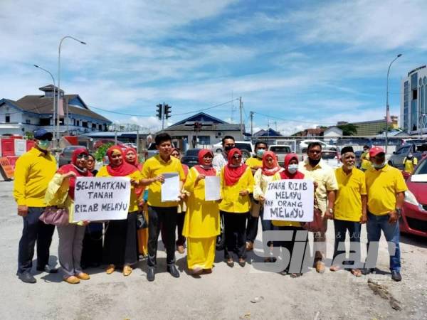 Hamidah (tengah) ketika di IPD Ipoh hari ini menunjukkan laporan polis yang dibuat berkaitan pemberian hak milik tanah rizab Melayu kepada bukan Melayu.