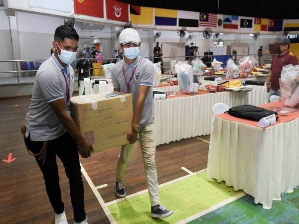 Petugas SPR mengangkat kotak berisi kertas undi sebagai persiapan untuk proses mengundi PRN Sabah esok di di Dewan Masyarakat Sandakan hari ini. Foto Bernama