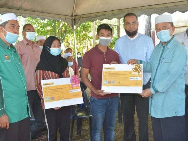 Muhammad Danial dan Nur Diyana menerima faedah yang disampaikan Mohammed Azman (dua dari kanan) semalam.