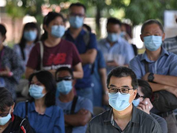 Pengundi dilihat mematuhi prosedur operasi standard (SOP) yang ditetapkan iaitu memakai pelitup muka dan mengamalkan jarak fizikal ketika mengundi pada Pilihan Raya Negeri Sabah di SK Sacred Heart hari ini.