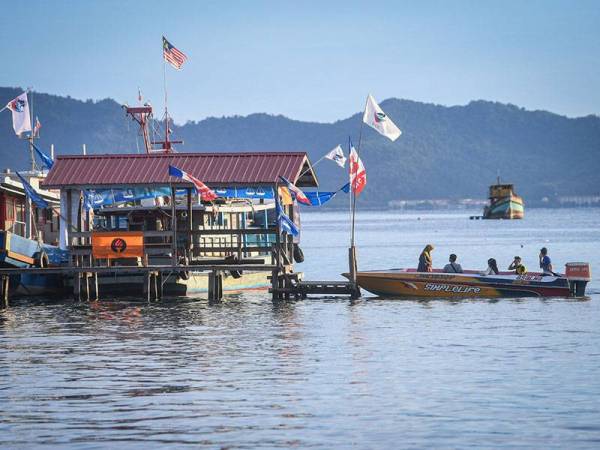 Orang ramai menaiki bot untuk mengundi sempena Pilihan Raya Negeri (PRN) Sabah di SK Pulau Gaya hari ini.