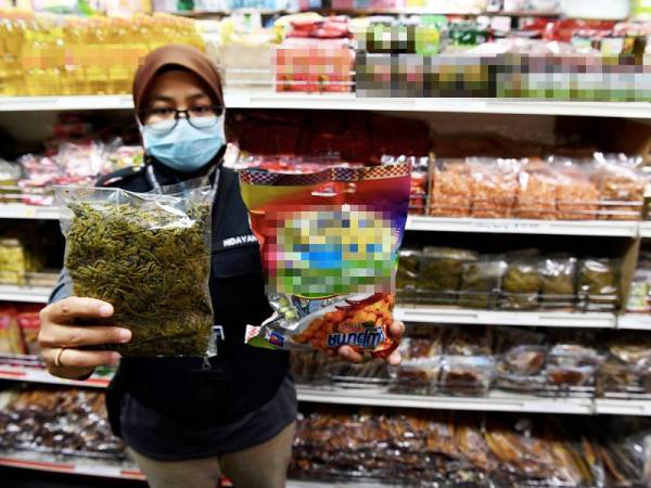 Penguatkuasa Jabatan Kesihatan Seberang Perai Tengah, Nurul Hidayah Abdullah menunjukkan barangan tidak berlabel dan label dalam tulisan bahasa asing yang dijual di sebuah kedai serbaneka di sebuah pusat membeli-belah semasa 'Ops Sapu' dijalankan oleh penguatkuasa bahagian Keselamatan dan Kualiti Makanan, Jabatan Kesihatan Negeri Pulau Pinang bersama Jabatan Siasatan Jenayah, Ibu Pejabat Polis Daerah Seberang Perai Tengah dan Majlis Bandaraya Seberang Perai, hari ini. - Foto bernama