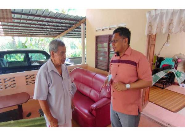 Syahrul Nizam Salleh (kanan) ketika bertemu salah seorang penduduk yang kediamannya terjejas.