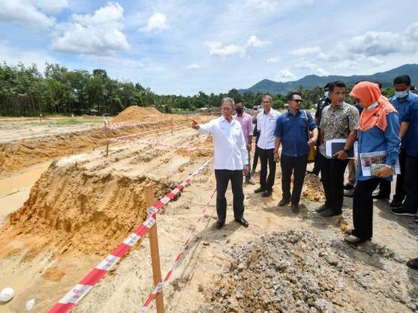 Mustapa (kiri) ketika melawat tapak projek Kolej Komuniti selepas Majlis Perasmian Tapak Projek Kolej Komuniti (KK) Jeli di Bukit Bunga hari ini.