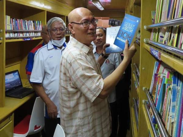 Nor Hisham menunjukkan antara koleksi buku yang terdapat di dalam Perkhidmatan Bas Perpustakaan Bergerak Wangsa Melawati di sini.