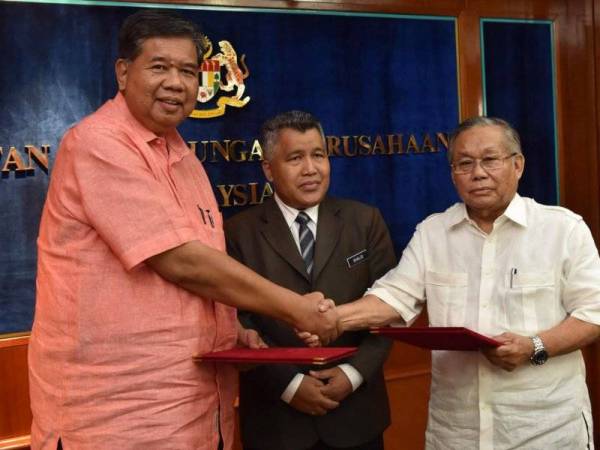 Zainal (kanan) selepas menandatangani perjanjian persetujuan (MoA) mengenai isu pemberhentian 23 pekerja bas awam Putrajaya sambil disaksikan Ketua Pengarah Jabatan Perhubungan Perusahaan, Khalid Jali (tengah) di Putrajaya pada 15 Ogos 2018.