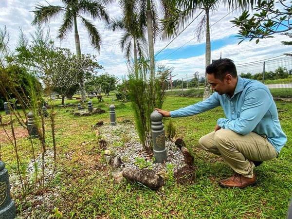 Ahmad Faiq menziarahi pusara bapanya di Tanah Perkuburan Islam Muasasah Darul Umum, Pokok Sena kelmarin.