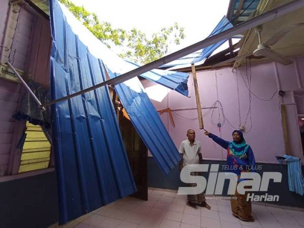 Rahimah dan suaminya menunjukan keadaan kediamannya yang rosak akibat kejadian itu.