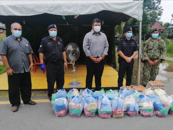Syed Mohd Johan Rizal (tengah) menyampaikan bantuan makanan kepada wakil petugas untuk diserahkan kepada penduduk Rumah Pangsa Tongkang Yard, Seberang Perak hari ini.