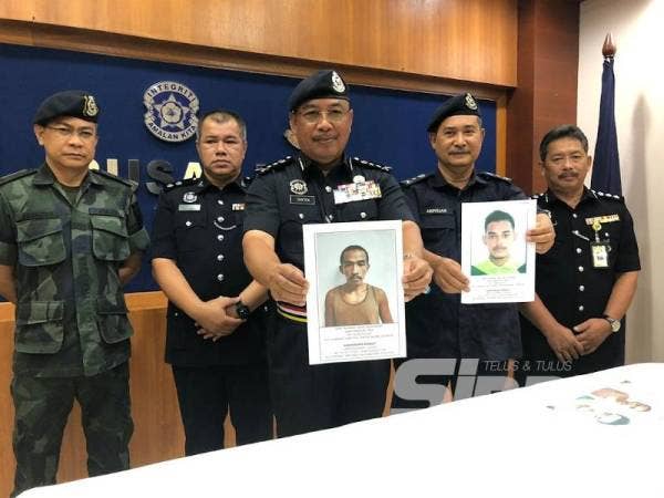 Shafien (tengah) menunjukkan gambar Mizi, manakala Timbalan beliau, Senior Asisten Komisioner Abdullah Mohammad Piah menunjukkan gambar Hafiz pada sidang akhbar di IPK Kota Bharu hari ini.