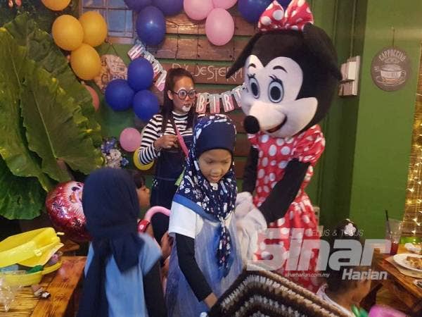 Intan Masyanie (belakang, kiri) tidak kisah menjadi badut untuk menceriakan kanak-kanak.