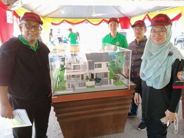 Siti Zubaidah (kanan) bersama pegawai-pegawai kanan PKNS menunjukkan model unit rumah yang dijual ketika Kempen Promosi 48 Jam Mesti Bell@Antara Gapi di Tasik Antara Gapi, Serendah kelmarin.