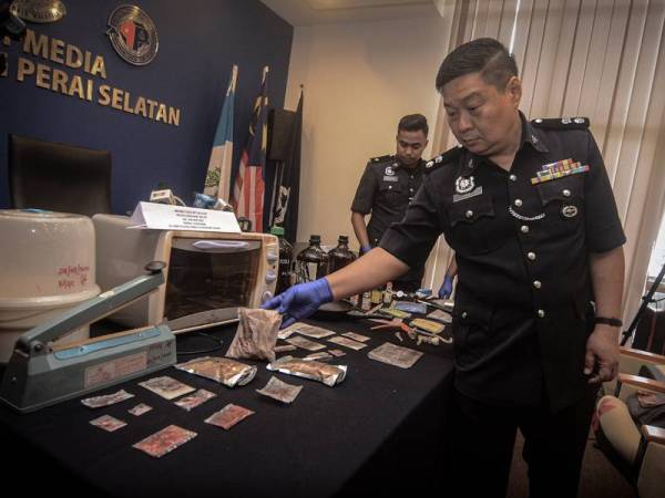 Chong Chern menunjukkan pelbagai jenis dadah yang dirampas dari pasangan terbabit.