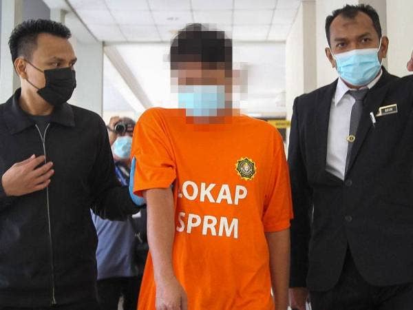 Pemilik syarikat pembekalan pasir (tengah) dibawa pegawai SPRM ke Mahkamah Khas Reman Seremban hari ini.