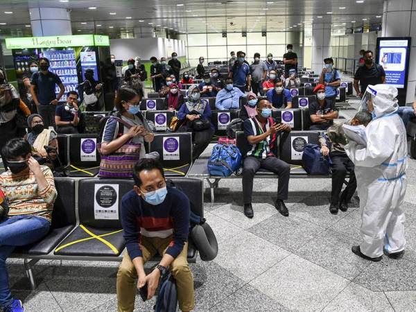 Petugas Kementerian Kesihatan Malaysia (KKM) memberi taklimat kepada para penumpang penerbangan dari Sabah sejurus tiba di Lapangan Terbang Antarabangsa Kuala Lumpur (KLIA) hari ini.