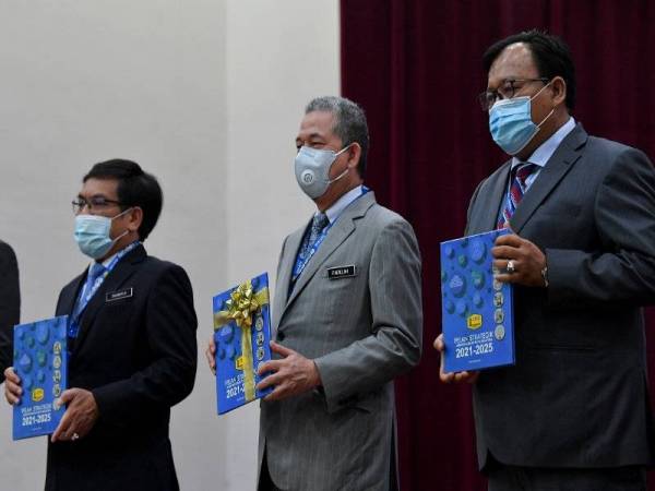 Fadillah (tengah) bersama Timbalannya, Datuk Eddin Syazlee Shith (kanan) dan Ketua Pengarah Kerja Raya, Datuk Ir Mohamad Zulkefly Sulaiman (kiri) memegang buku Pelan Strategik Jabatan Kerja Raya 2021-2025 pada majlis yang diadakan di Kuala Lumpur hari ini. - Foto Bernama