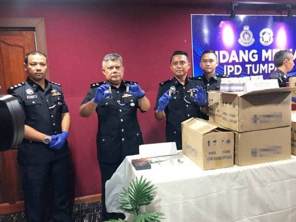 Ketua Polis daerah, Superintendan Ab Rashid Mat Daud (dua dari kanan) menunjukkan heroin dalam botol yang ditemui di atas atap zink sebuah bangunan di Wakaf Bharu, Tumpat.