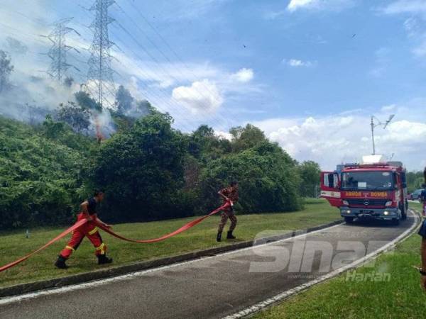 Pasukan Bomba dan Penyelamat berusaha memadamkan api di kawasan bukit dekat Putrajaya hari ini.