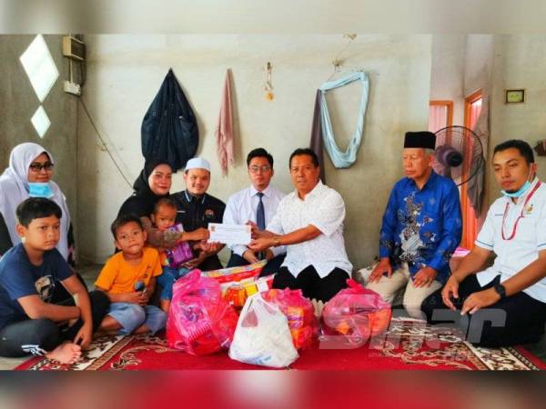 Muhamad Danial Ikhwan (kiri) dan ibunya, Rosida Riza menerima sumbangan wang zakat daripada Yayasan Amal Datuk Zul Wisma yang disampaikan oleh Zulkepli (tiga dari kanan) di rumah mereka di Kampung Kusar, Gual Periok, Rantau Panjang hari ini.