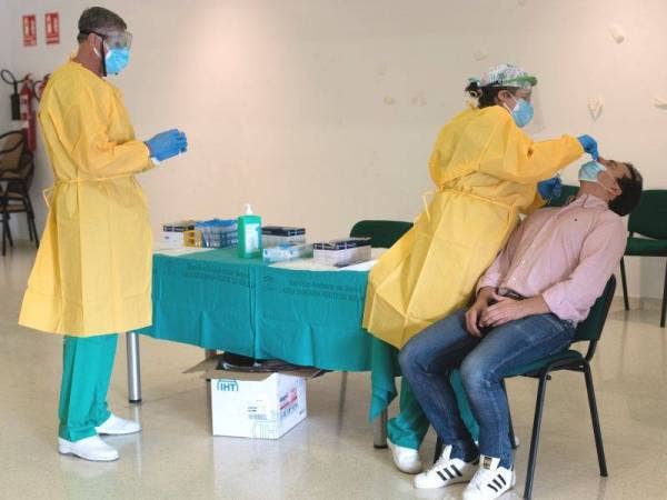 Kakitangan kesihatan mengambil sampel swab ketika ujian secara beramai-ramai di Sierra de Yeguas di wilayah Malaga. - Foto AFP