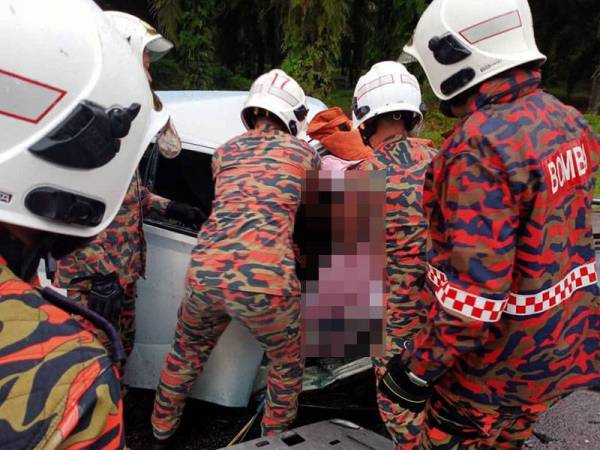 Anggota bomba mengeluarkan dua mangsa yang tersepit selepas kereta Perodua Viva dinaiki terlibat kemalangan dengan treler di Felcra Sungai Ara, Kota Tinggi hari ini.